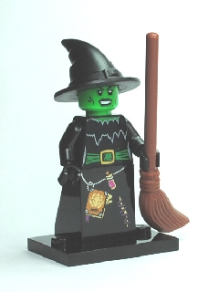 Toy figure of a witch with a broom on a white background