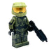 A custom-built toy minifigure resembling Master Chief from Halo, wearing olive green armor with a gold visor and holding a black blaster, set against a plain white background.