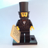 LEGO figure of a man in a top hat holding a document on a white background
